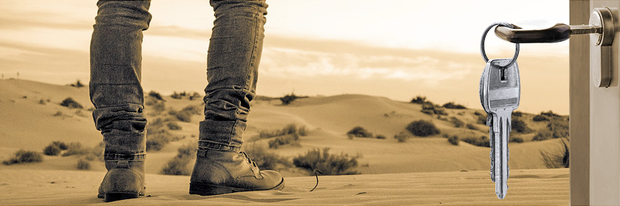 Mietnomadenversicherung – Schlüssel hängt an Wohnungstür, Beine eines Mannes der in die Wüste läuft